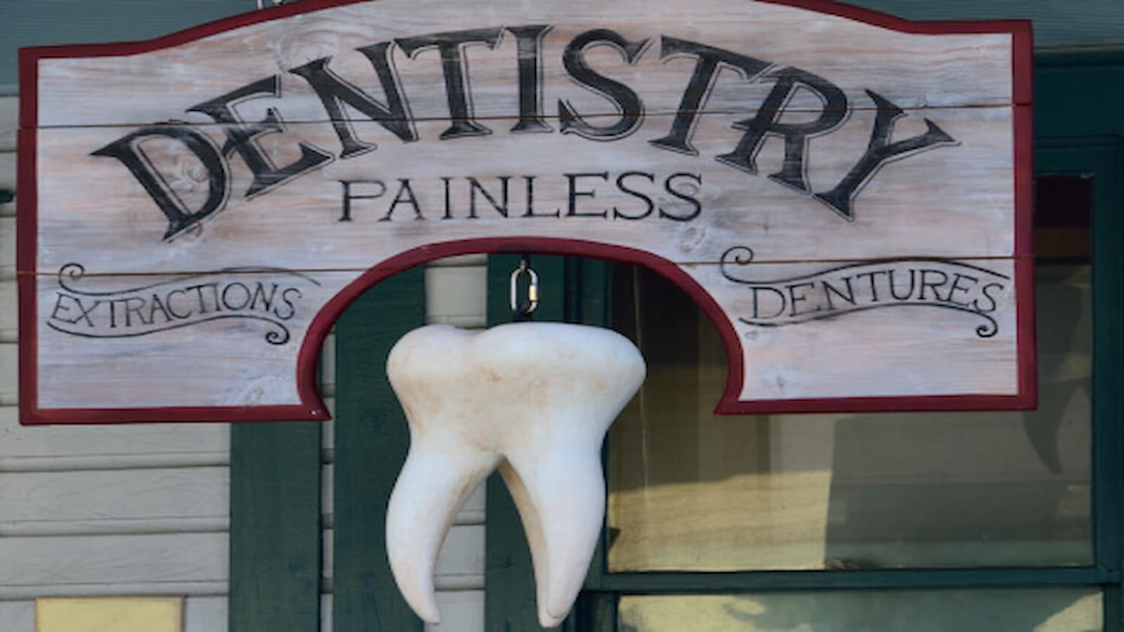 A Board that reads "DENTISTRY, PAINLESS"